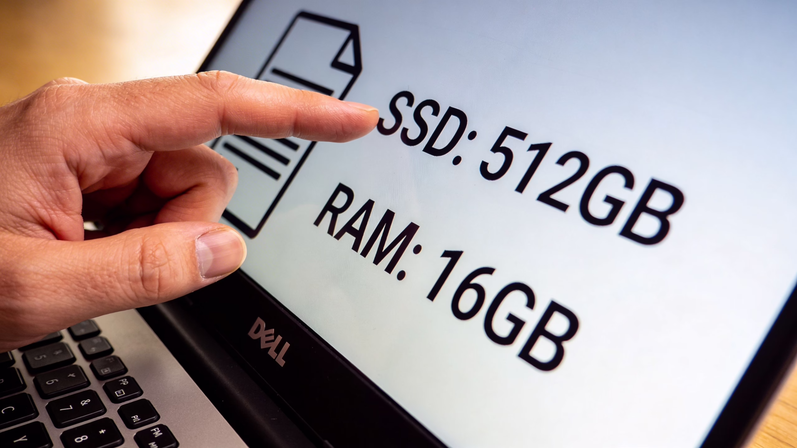 Cheap Dell Laptops: A UK Buyer's Guide for 2026 3 A hand pointing at a laptop screen displaying 512GB SSD and 16GB RAM specifications.