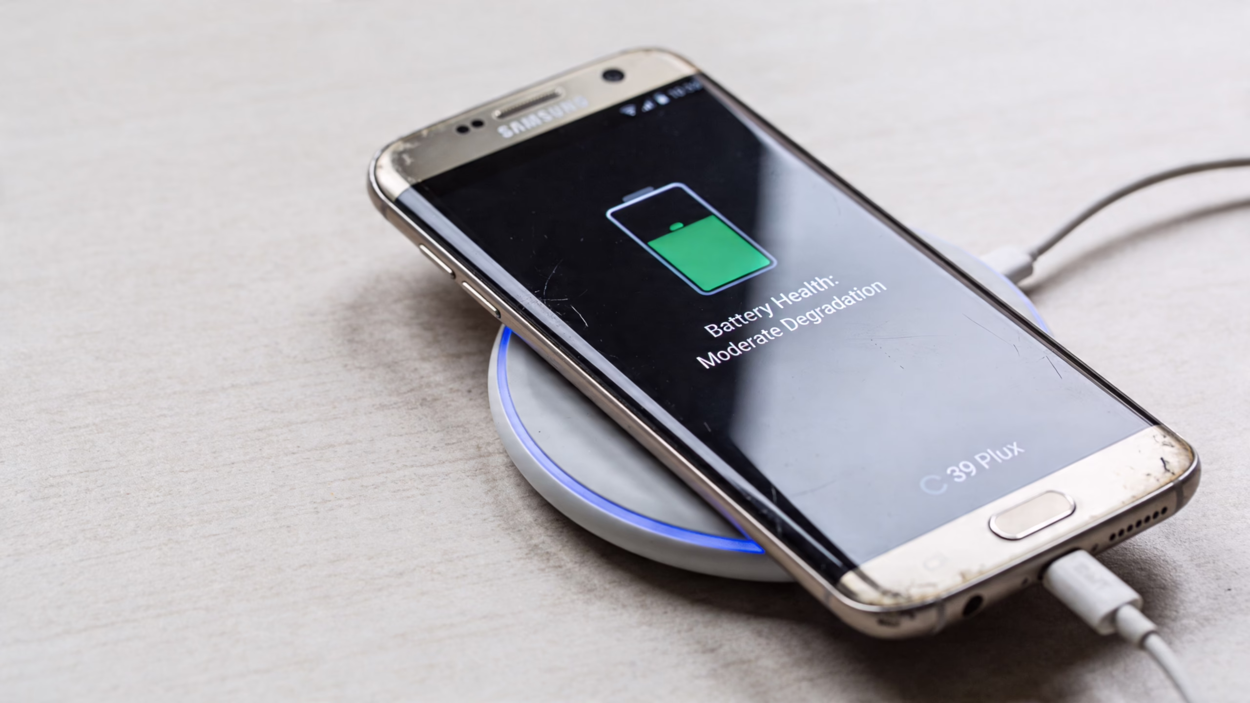 Samsung S9 Plus in 2026: A UK Buyer's Guide 2 A Samsung smartphone placed on a wireless charging pad, displaying a battery health notification on the screen.