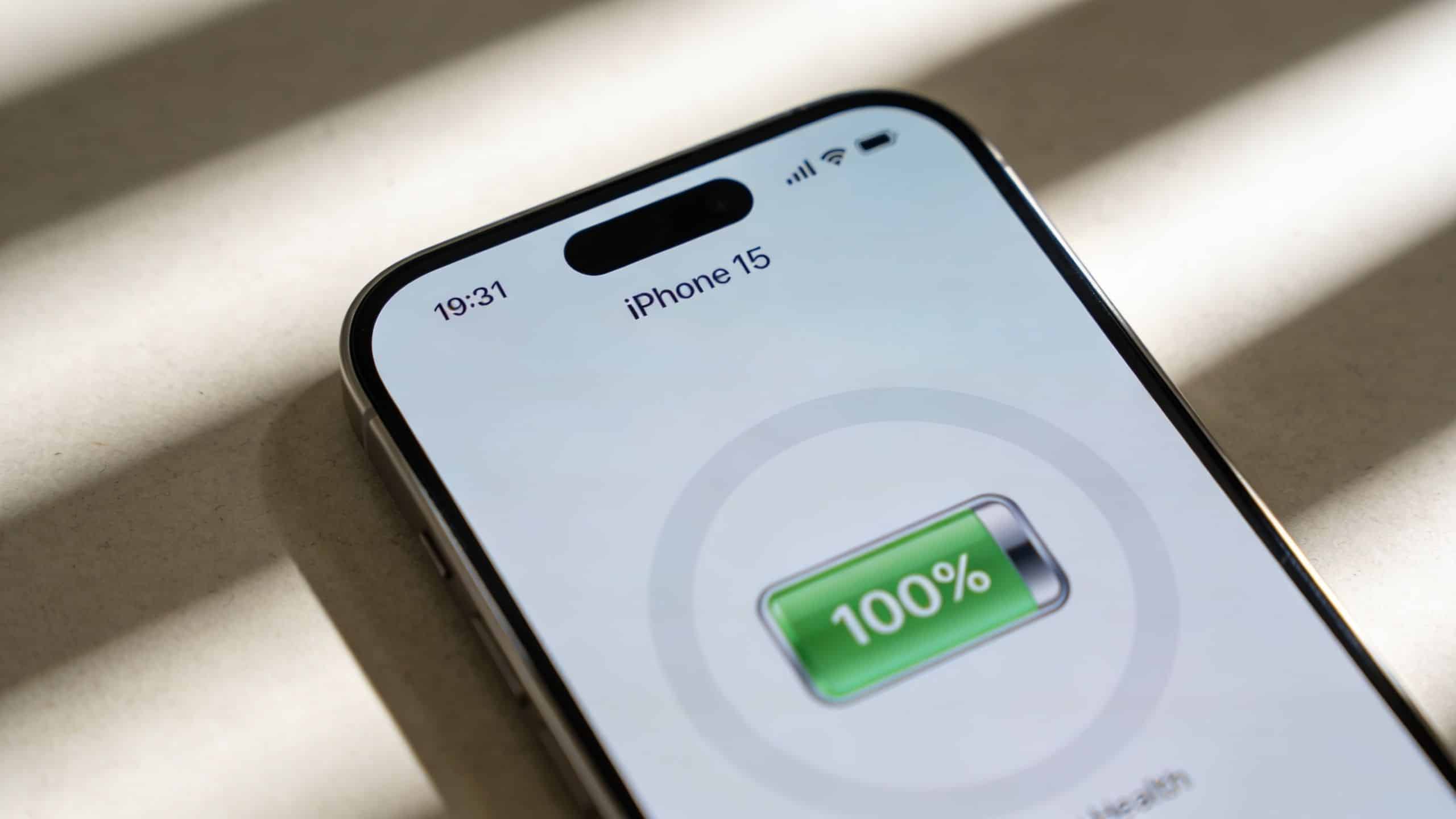 Refurbished iPhone 15 UK: 2026 Buyer's Guide 1 A close-up shot of an iPhone 15 screen displaying a 100% battery charge level indicator.