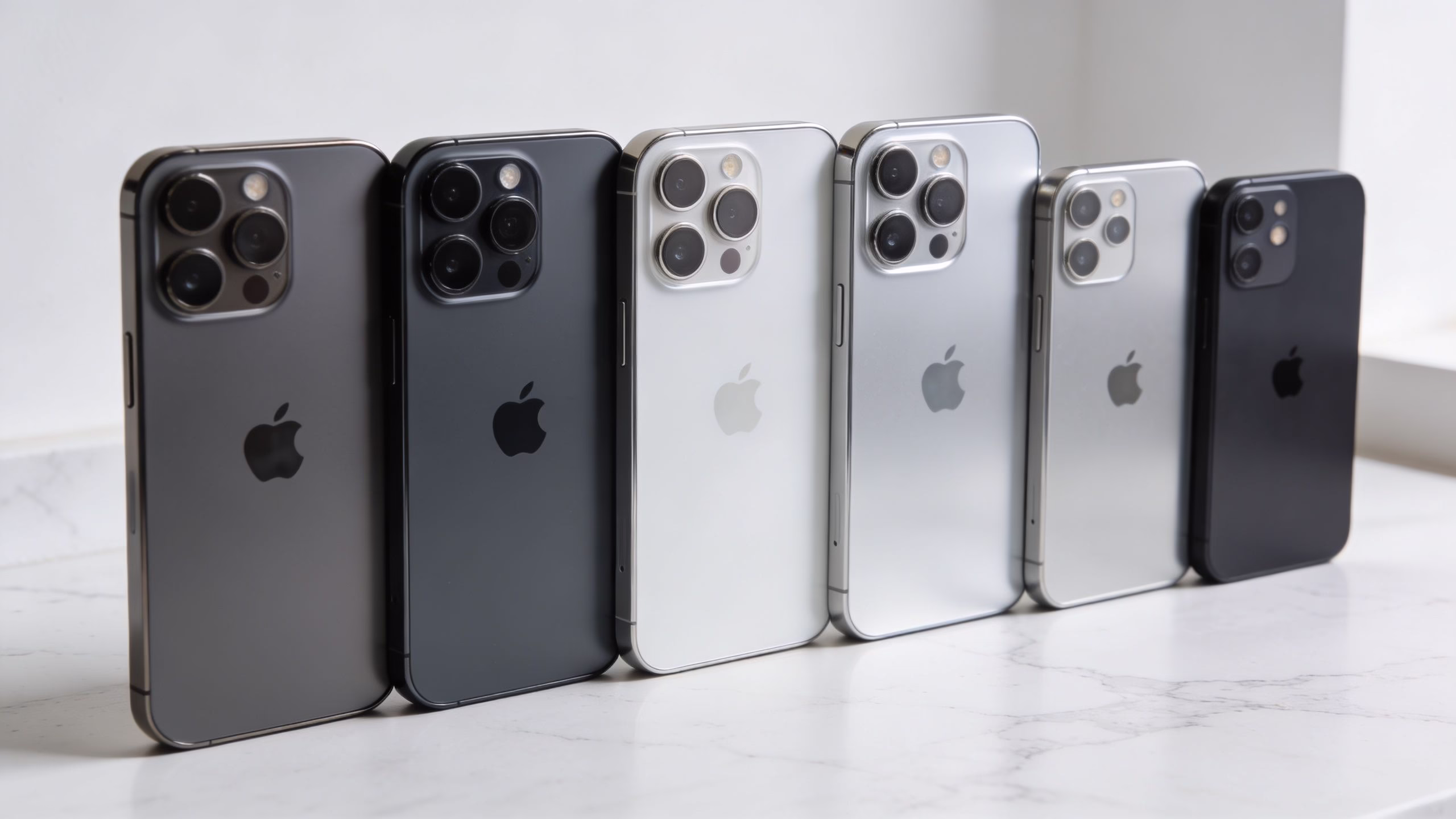Refurbished iPhone Next Day Delivery UK: 2026 Buying Guide 3 A row of various Apple iPhones standing upright on a white marble surface for comparison