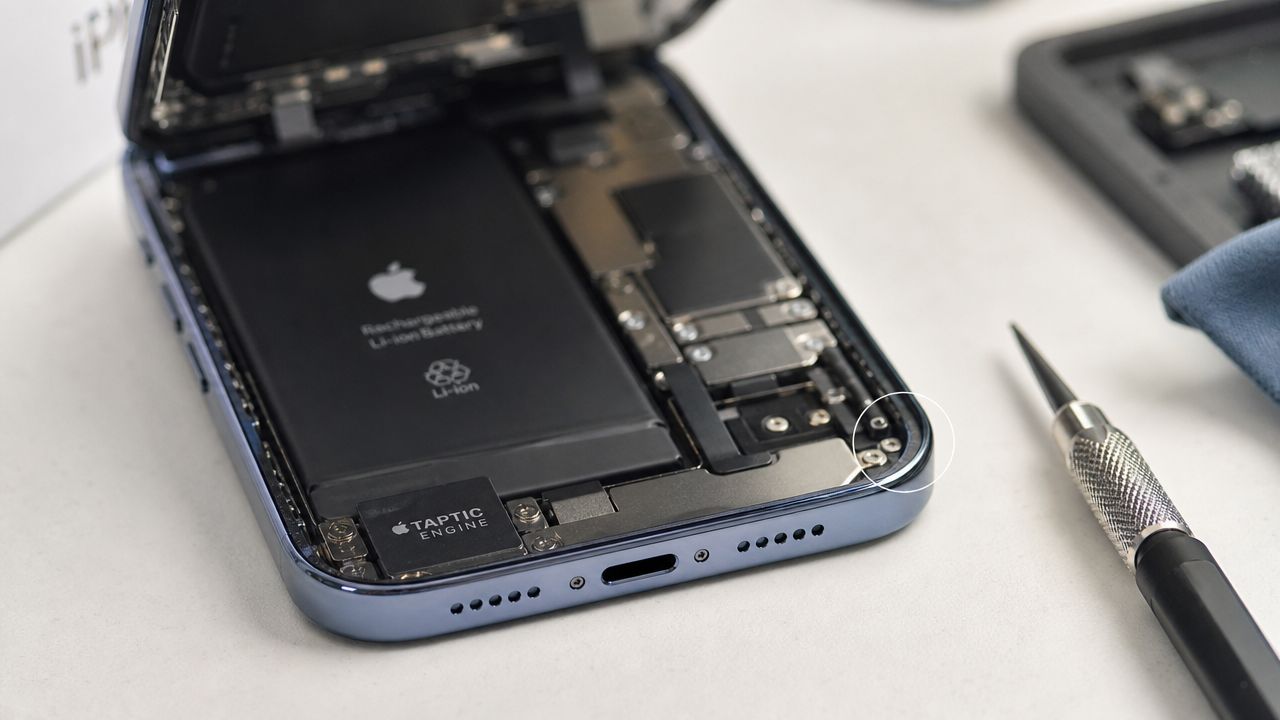 Are Refurbished iPhones Waterproof? What You Need to Know 1 A disassembled smartphone showing its internal battery, Taptic Engine, and metallic casing components on a repair desk.