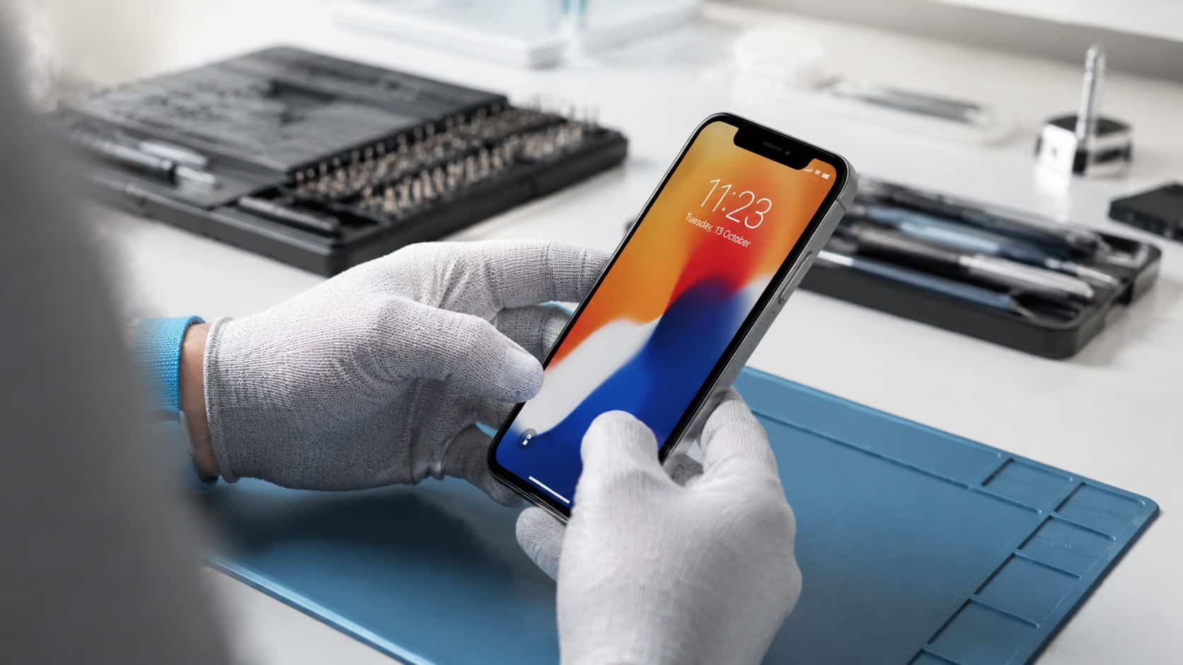 How to Adjust Screen Brightness on Any Device 3 A technician wearing white protective gloves holds a smartphone during a mobile device repair process.