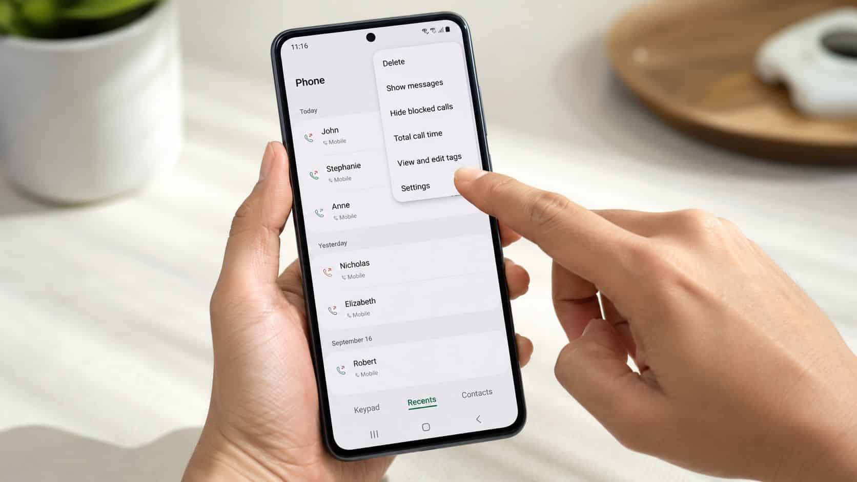 How to Set Up Call Forwarding on Any Phone 5 A person holding a smartphone and navigating the phone call settings menu on the touchscreen display.