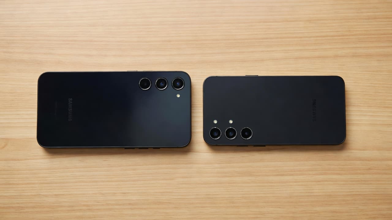 Galaxy A55 vs S23 FE: Refurbished Value in 2026 1 Two Samsung smartphones are resting side by side on a clean wooden desktop.